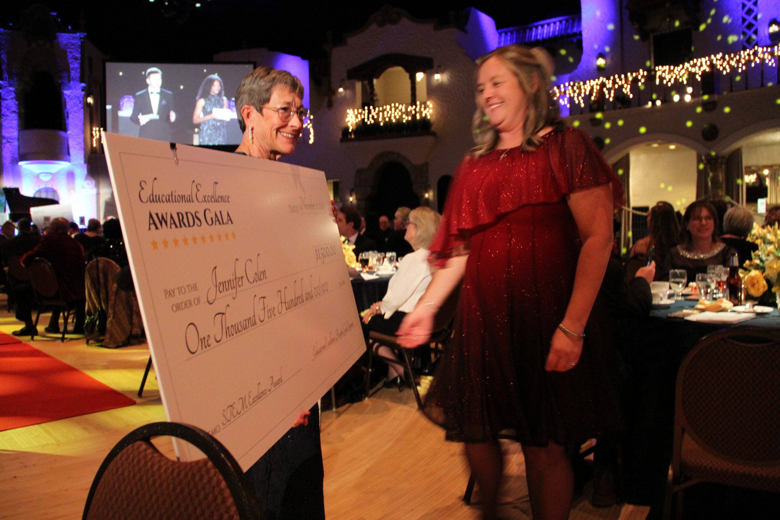 A teacher is awarded with a check at the Educational Excellence Awards Gala