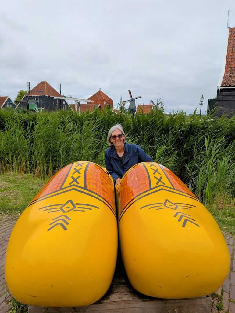 Jen Shenberger sitting in a very oversized pair of clogs